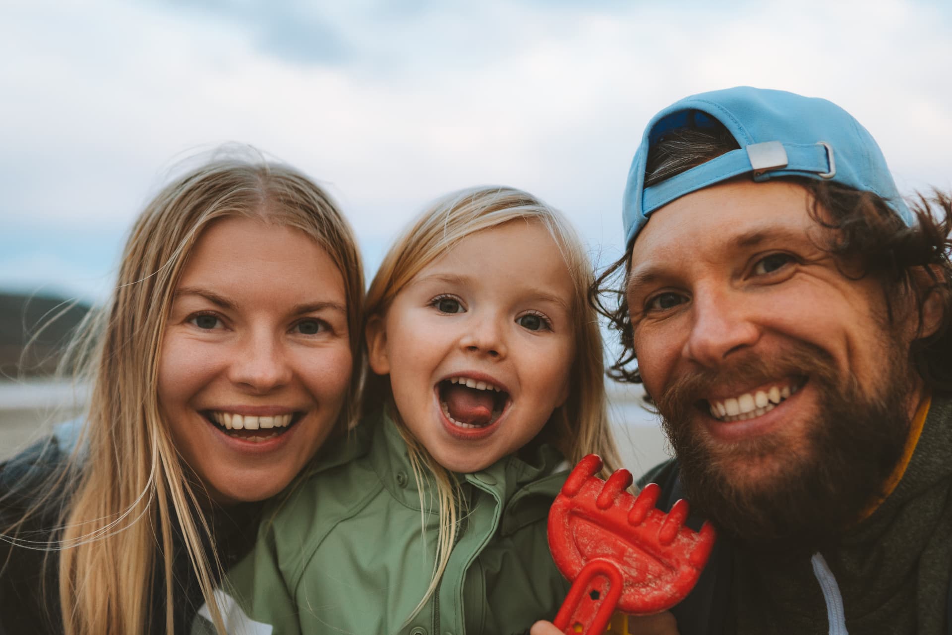 Familj som skrattar tillsammans vid havet